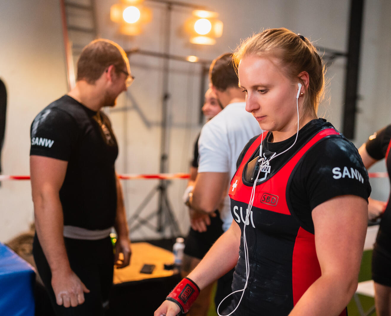 Andrea Marx Prep with Powerlifting Coach in Zürich Powerlifting coach and athlete preparing backstage at a Zürich competition, demonstrating focused coaching, mental preparation, and elite strength training support.