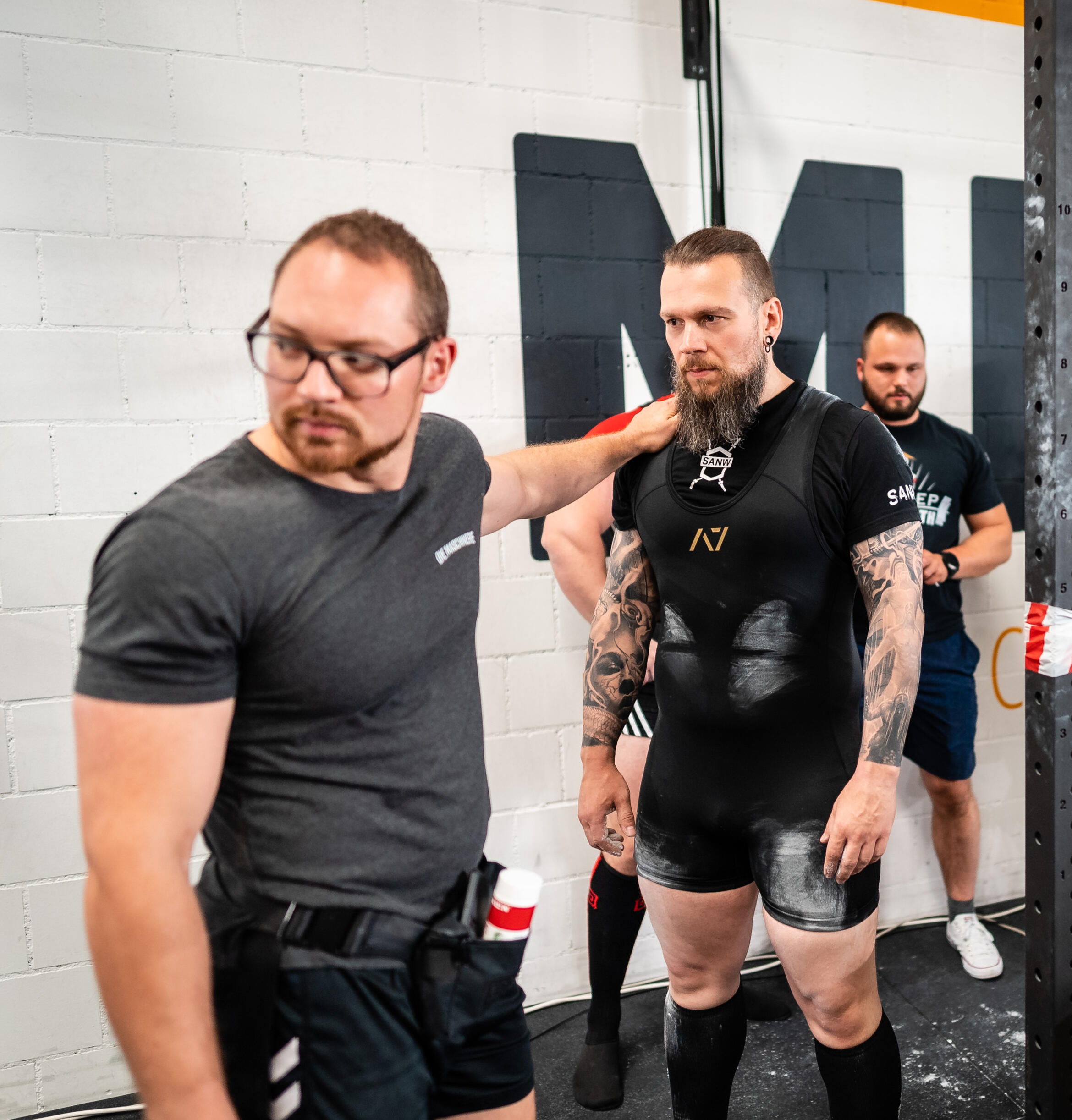 Powerlifting Coach Preparing Athlete for Competition Platform Expert powerlifting coach guiding an athlete moments before stepping onto the competition platform, showcasing peak performance preparation, strength training focus, and competition-day strategy.